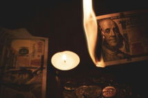 white pillar candle beside 100 us dollar bill